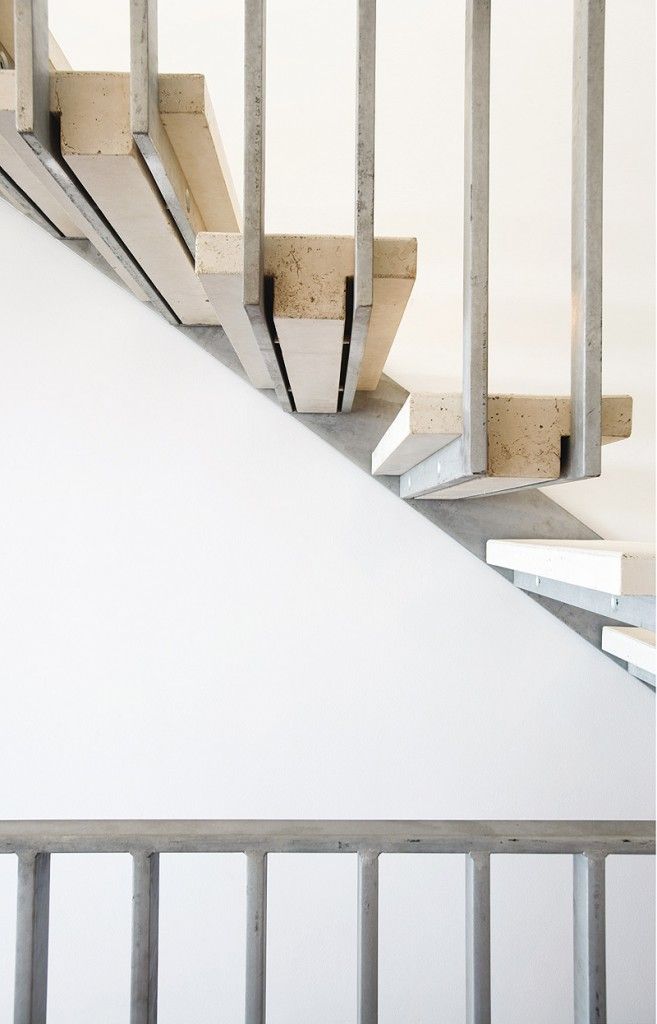 Close-up of a modern staircase with metal railings and pale wooden treads, minimalist and clean mood